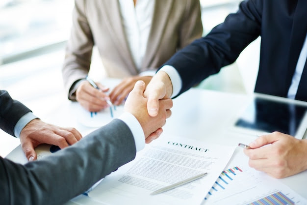 Businesspeople shaking hands over a contract, symbolizing a business expansion deal in Vietnam.